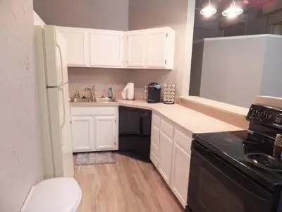 a small kitchen with white cabinets and a black appliance at Renovated Downtown Condo in the HEART OF IT ALL in Cleveland