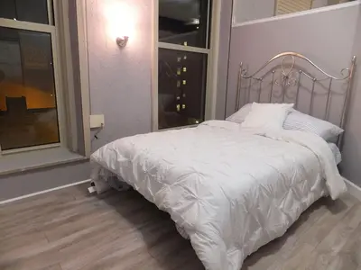 a white bed in a room with a window at Renovated Downtown Condo in the HEART OF IT ALL in Cleveland