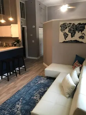 a living room with a white couch and a kitchen at Renovated Downtown Condo in the HEART OF IT ALL in Cleveland