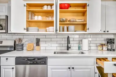 a kitchen with white cabinets and a sink at Fenced & Pet-Friendly! Modern 2BR Retreat! CLE-BW in Berea