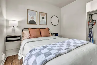 a bedroom with a bed with a checkered blanket at Fenced & Pet-Friendly! Modern 2BR Retreat! CLE-BW in Berea