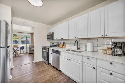 a kitchen with white cabinets and stainless steel appliances at Fenced & Pet-Friendly! Modern 2BR Retreat! CLE-BW in Berea