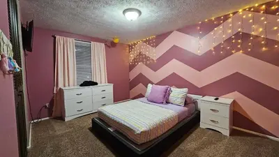 a bedroom with a bed and a pink and white wall at 3 BDR - Your Perfect Getaway! in Warren