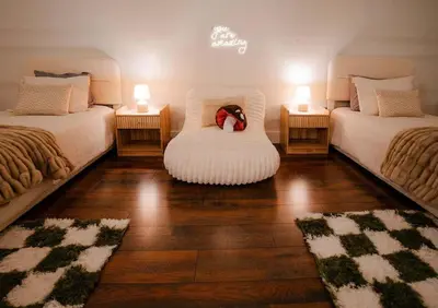 a room with two beds with a teddy bear sitting on a chair at The 312 House - A Boho Retreat- Hocking Hills in Logan