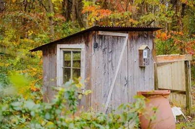 a small wooden shed with a window and a bird house at The 312 House - A Boho Retreat- Hocking Hills in Logan