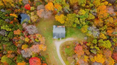 an aerial view of a house on a road in a forest at The 312 House - A Boho Retreat- Hocking Hills in Logan