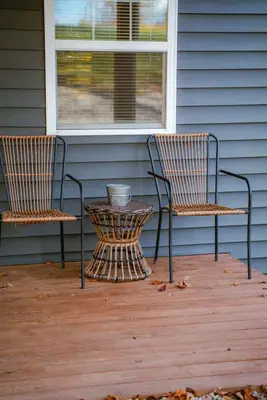 two chairs and a table on a porch at The Treetop A Hocking Hills Villa Treat in Logan