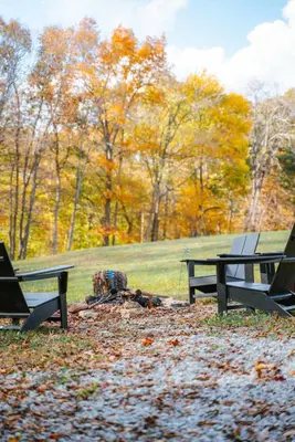 two picnic tables in a park with leaves on the ground at The Treetop A Hocking Hills Villa Treat in Logan