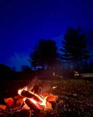 a fire in a field at night at The Treetop A Hocking Hills Villa Treat in Logan