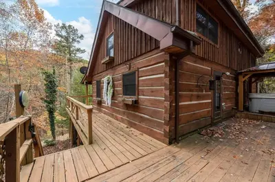 a log cabin with a large wooden deck at Outdoors Sleeps7 Family Getaway Fun Arcade Villa in Rockbridge