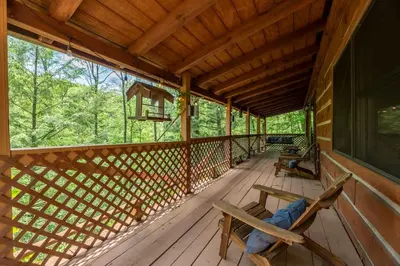 a porch of a cabin with two chairs on it at Outdoors Sleeps7 Family Getaway Fun Arcade Villa in Rockbridge