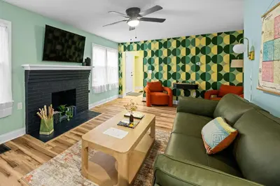 a living room with a green couch and a fireplace at 4BR, Home Theater, near Spooky Nook Sports Complex in Hamilton
