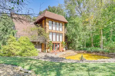 a house with a pond in front of it at Walk to School House Winery Home with Deck! in Dover