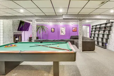 a pool table in a library with purple walls at Walk to School House Winery Home with Deck! in Dover