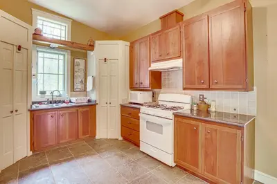 a kitchen with wooden cabinets and a white stove top oven at Romantic Pondside Escape Country Cottage in Paris in Paris