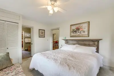 a bedroom with a white bed and a ceiling fan at Romantic Pondside Escape Country Cottage in Paris in Paris