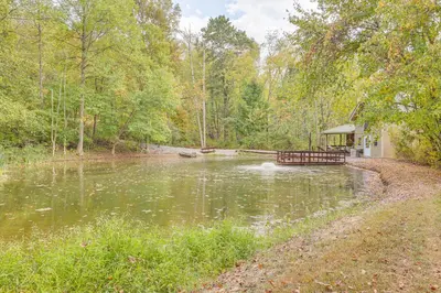 a pond with a house in the middle of it at Romantic Pondside Escape Country Cottage in Paris in Paris