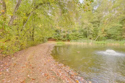 a dirt road next to a body of water at Romantic Pondside Escape Country Cottage in Paris in Paris