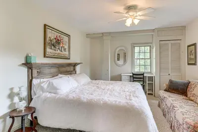 a bedroom with a white bed and a couch at Romantic Pondside Escape Country Cottage in Paris in Paris
