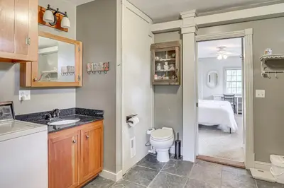 a bathroom with a toilet and a sink and a bedroom at Romantic Pondside Escape Country Cottage in Paris in Paris