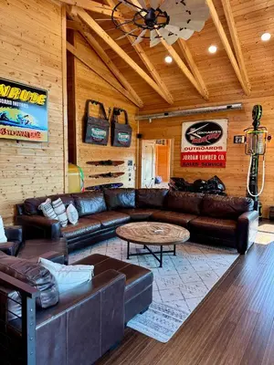 a living room with a leather couch and a table at Lake Therapy at The ARK | Gameroom, Hot Tub, Dock in Williamstown
