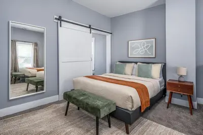 a bedroom with a large bed and a mirror at Walnut Hills, 5min to UC, Sleeps 7ppl, Lux Beds, Smart TVs in Cincinnati