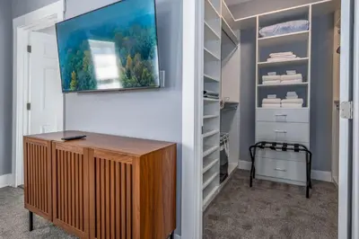 a room with a closet with a tv on a wall at Walnut Hills, 5min to UC, Sleeps 7ppl, Lux Beds, Smart TVs in Cincinnati