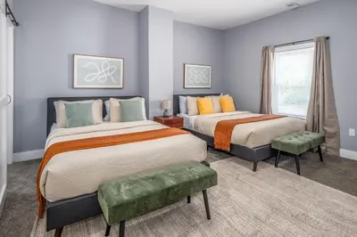 a bedroom with two beds and a window at Walnut Hills, 5min to UC, Sleeps 7ppl, Lux Beds, Smart TVs in Cincinnati