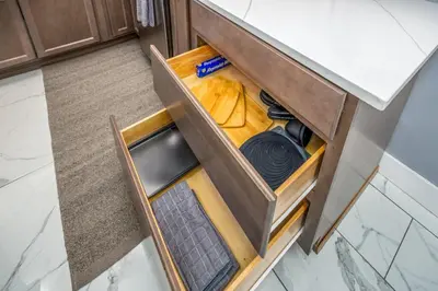 an open drawer in a kitchen with a counter at Prime Walnut Hills, 5min to UC, Lux King Beds, Sleep 6ppl, Smart TVs in Cincinnati