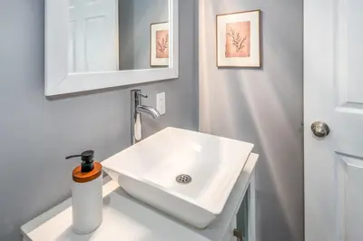 a bathroom with a white sink and a mirror at Prime Walnut Hills, 5min to UC, Lux King Beds, Sleep 6ppl, Smart TVs in Cincinnati
