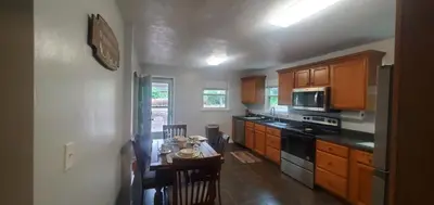 a kitchen with wooden cabinets and a small table with a table at Cottage in the Woods in Washington