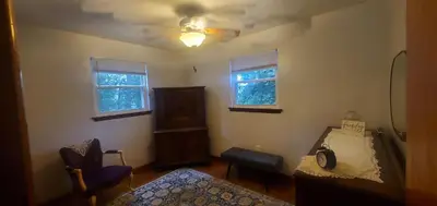 a bedroom with a bed and a ceiling fan at Cottage in the Woods in Washington