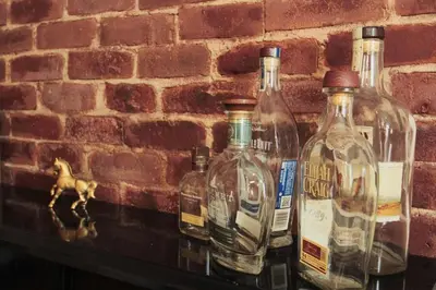a group ofempty bottles on a shelf against a brick wall at 1880s Georgetown Jewel in Georgetown
