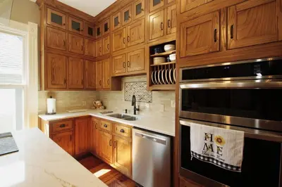 a kitchen with wooden cabinets and a stainless steel appliance at 1880s Georgetown Jewel in Georgetown