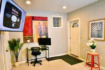 a living room with a television and a desk and stool at Large 4 bedroom Tremont House - Bonus apartment included! in Cleveland