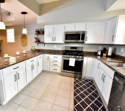 a kitchen with white cabinets and a stove top oven at Large 4 bedroom Tremont House - Bonus apartment included! in Cleveland