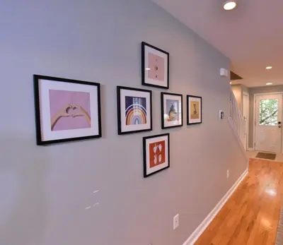 a group of framed pictures on a white wall at Large 4 bedroom Tremont House - Bonus apartment included! in Cleveland