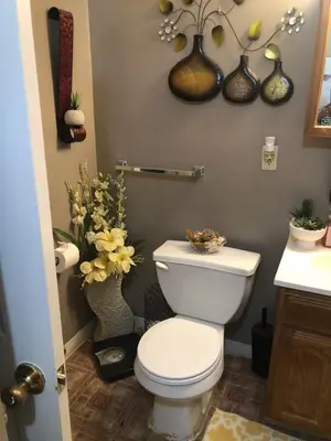 a bathroom with a toilet and vases of flowers at Suite Serenity in Cleveland