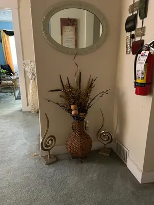 a vase with flowers in a hallway with a mirror at Suite Serenity in Cleveland