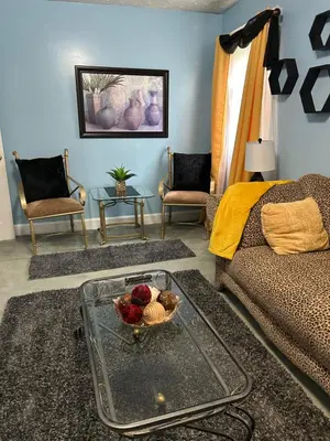 a living room with a bowl of fruit on a glass table at Suite Serenity in Cleveland