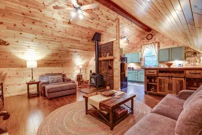 a living room with a couch and a table in a cabin at Hot Tub Haven 10 Mi to Hocking Hills State Park! in Amanda
