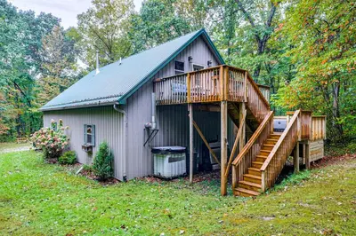 a large house with a large deck and a porch at Hot Tub Haven 10 Mi to Hocking Hills State Park! in Amanda