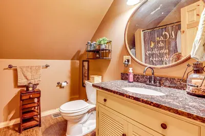 a bathroom with a toilet and a sink and a mirror at Hot Tub Haven 10 Mi to Hocking Hills State Park! in Amanda