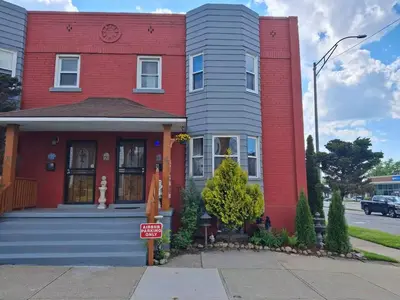 a red and gray house with a for sale sign in front at The Boulevard Stay in Cleveland