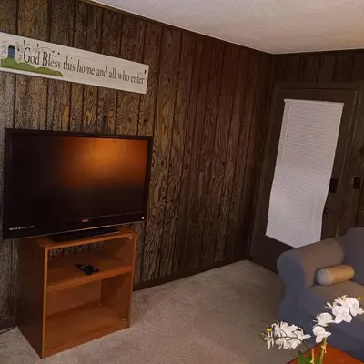 a living room with a flat screen tv on a wooden wall at The Unique Spot in Cleveland