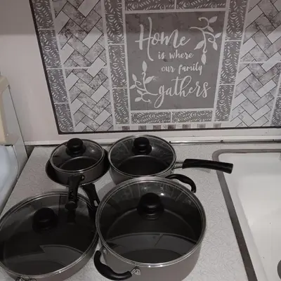 three pots on top of a stove with a chalkboard at The Unique Spot in Cleveland