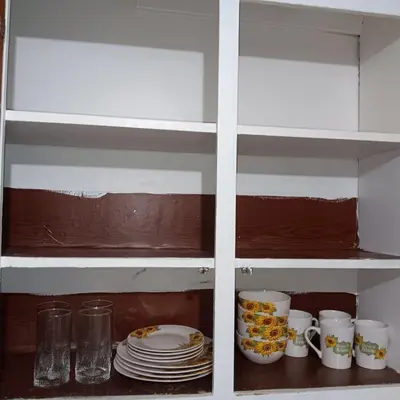 a cupboard with plates and mugs in it at The Unique Spot in Cleveland