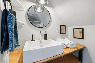 a bathroom with a white sink and a mirror at Cozy escape with Hot Tub, ideal for family & friends in Columbus