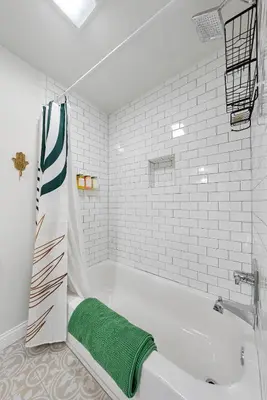 a bathroom with a bath tub with a green towel at Cozy escape with Hot Tub, ideal for family & friends in Columbus
