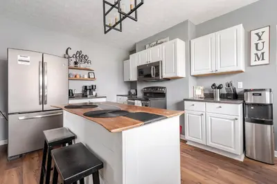 a kitchen with white cabinets and stainless steel appliances at 5BR/3BA*Game Room*FirePit*Theater*3 mins to ARK! in Williamstown